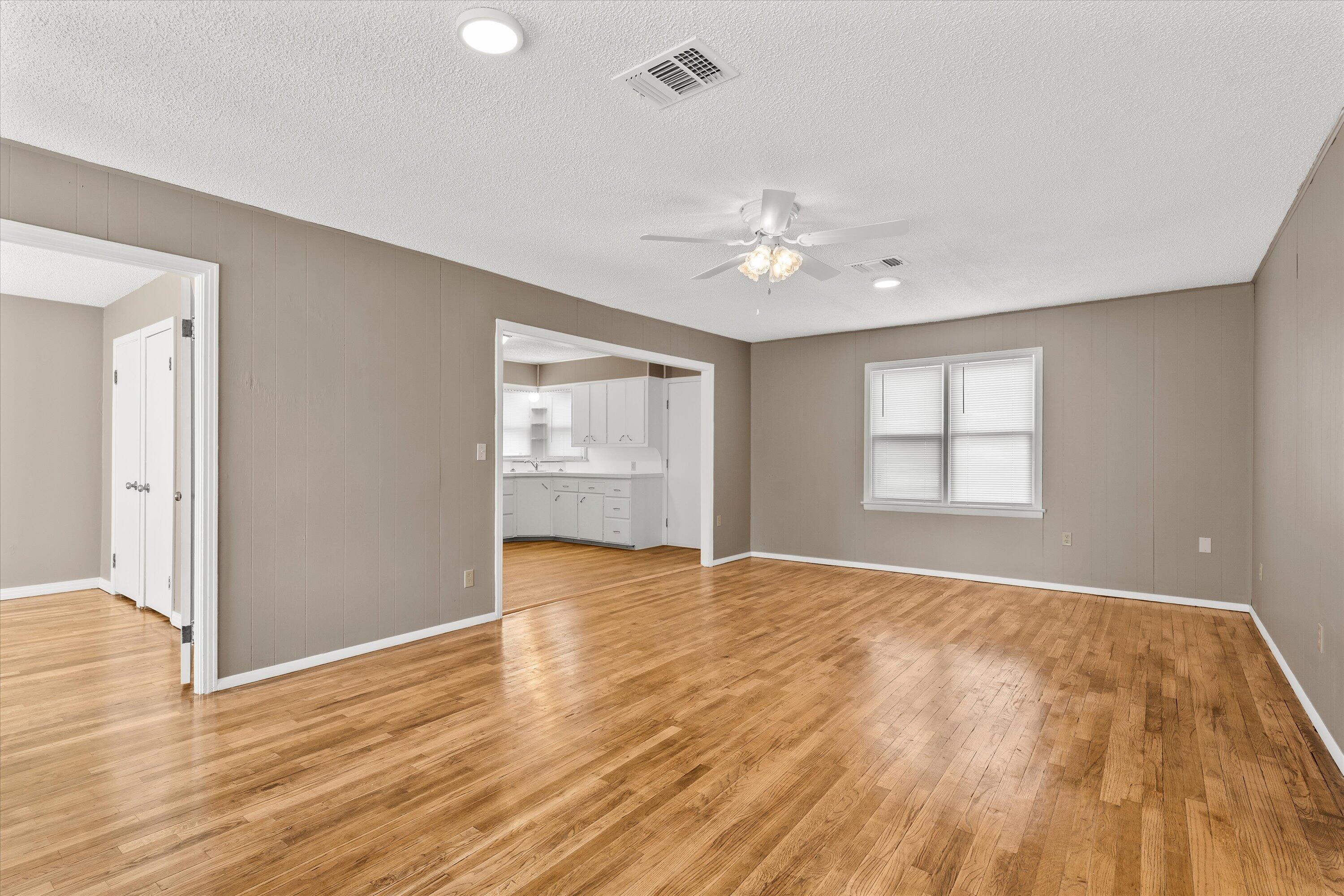 107 Hickory Street Levelland, TX 79336 - Photo 5 of 21 a view of an empty room with a window and wooden floor