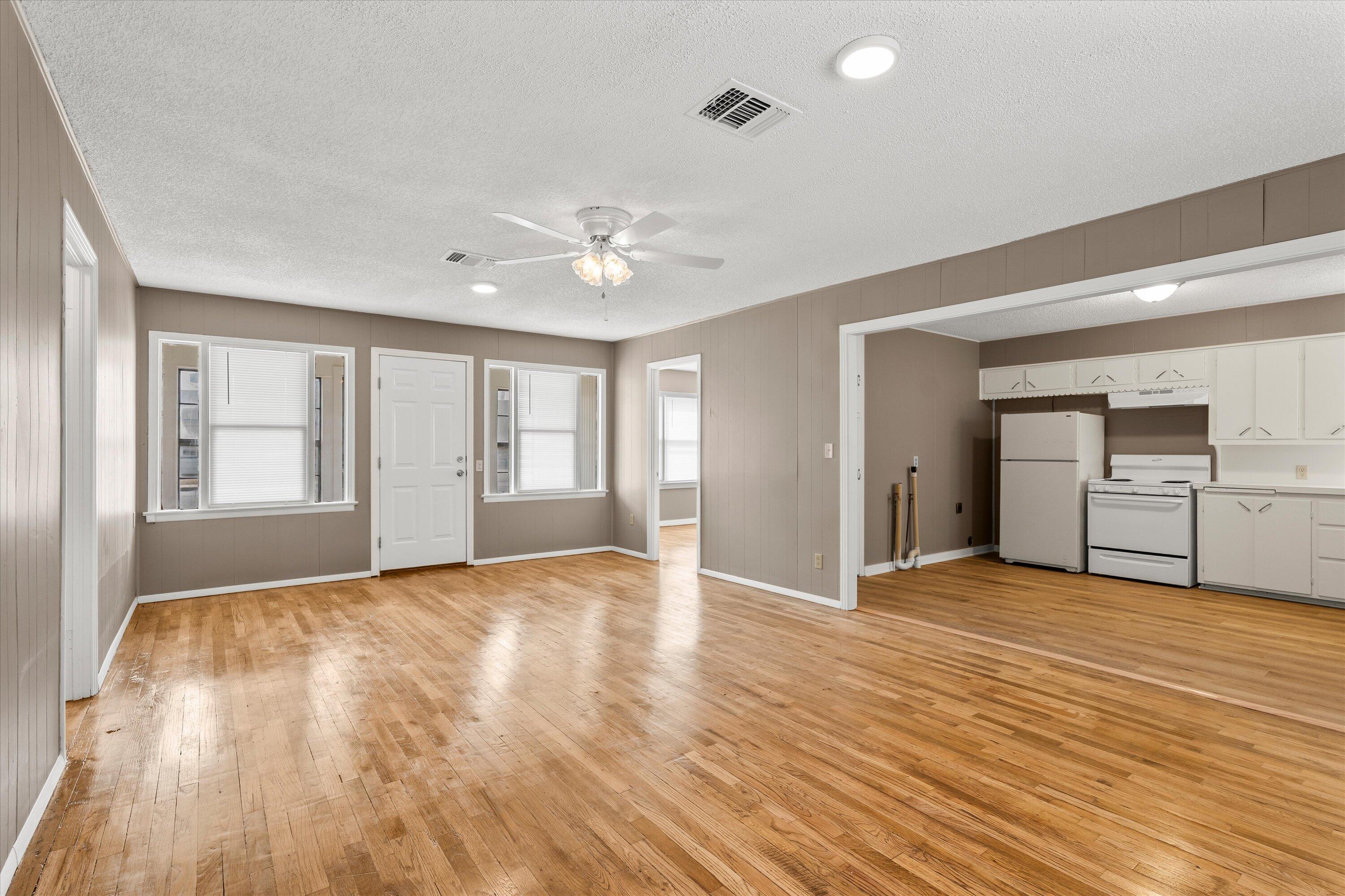 107 Hickory Street Levelland, TX 79336 - Photo 6 of 21 a view of an empty room with window and wooden floor