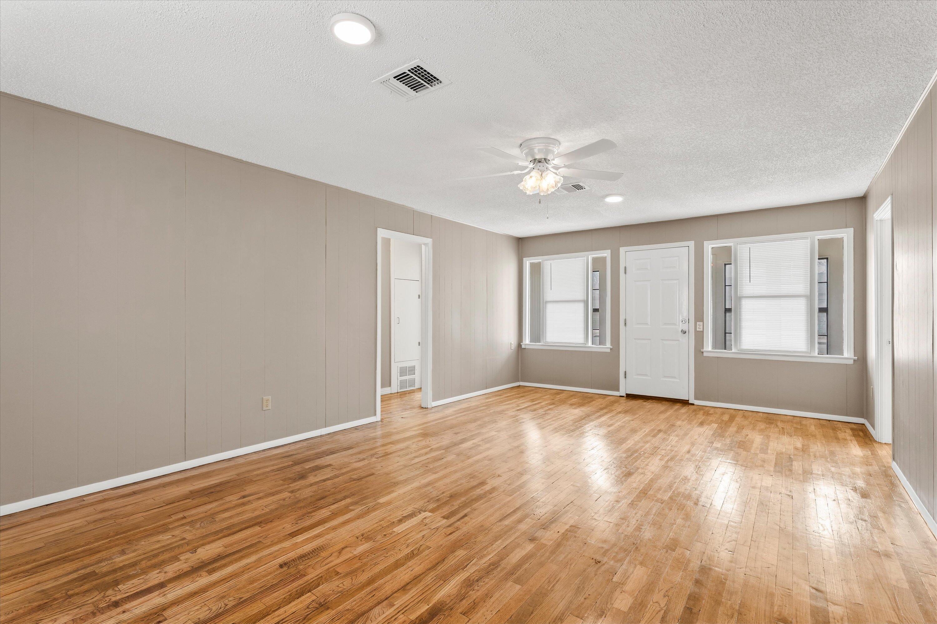 107 Hickory Street Levelland, TX 79336 - Photo 7 of 21 a view of an empty room with window and wooden floor
