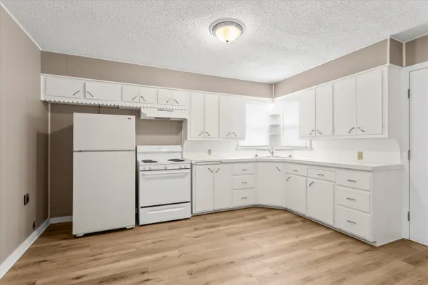 a kitchen with white cabinets and white appliances