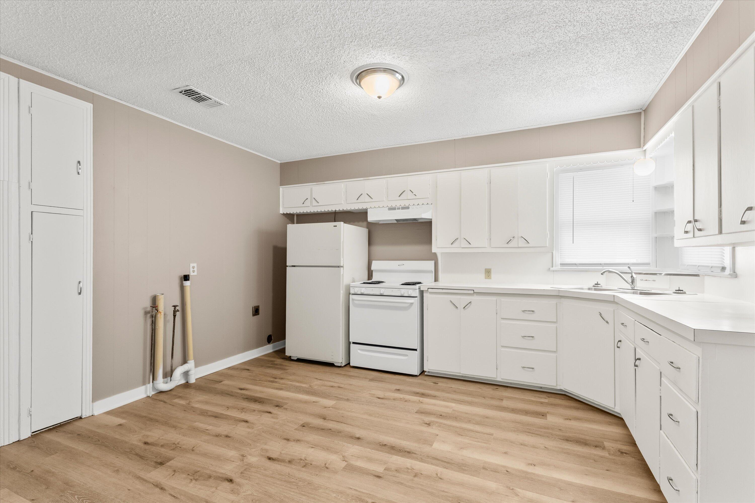 107 Hickory Street Levelland, TX 79336 - Photo 9 of 21 a kitchen with white cabinets and white appliances