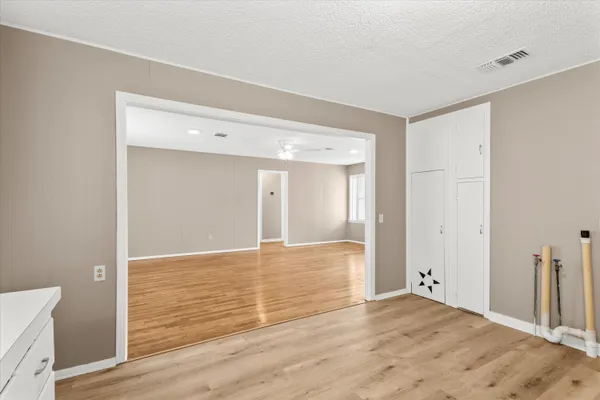 a view of an empty room with wooden floor
