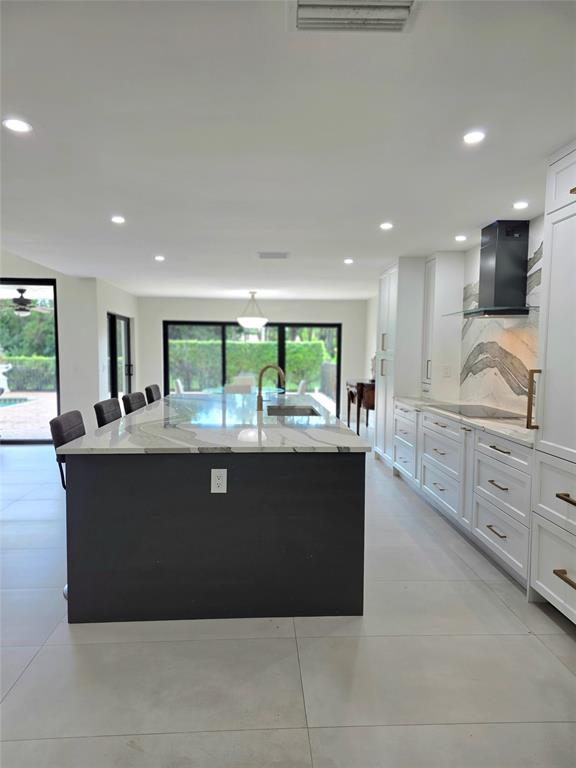 10486 Boca Woods Lane Boca Raton, FL 33428 - Photo 4 of 18 a living room with stainless steel appliances kitchen island granite countertop a refrigerator a sink a stove and a oven with wooden floor
