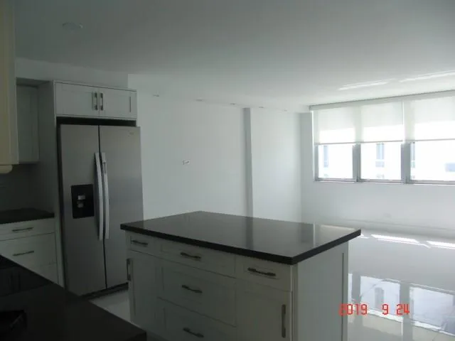 a kitchen with kitchen island cabinets and refrigerator