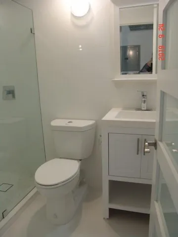 a bathroom with a toilet a sink and mirror