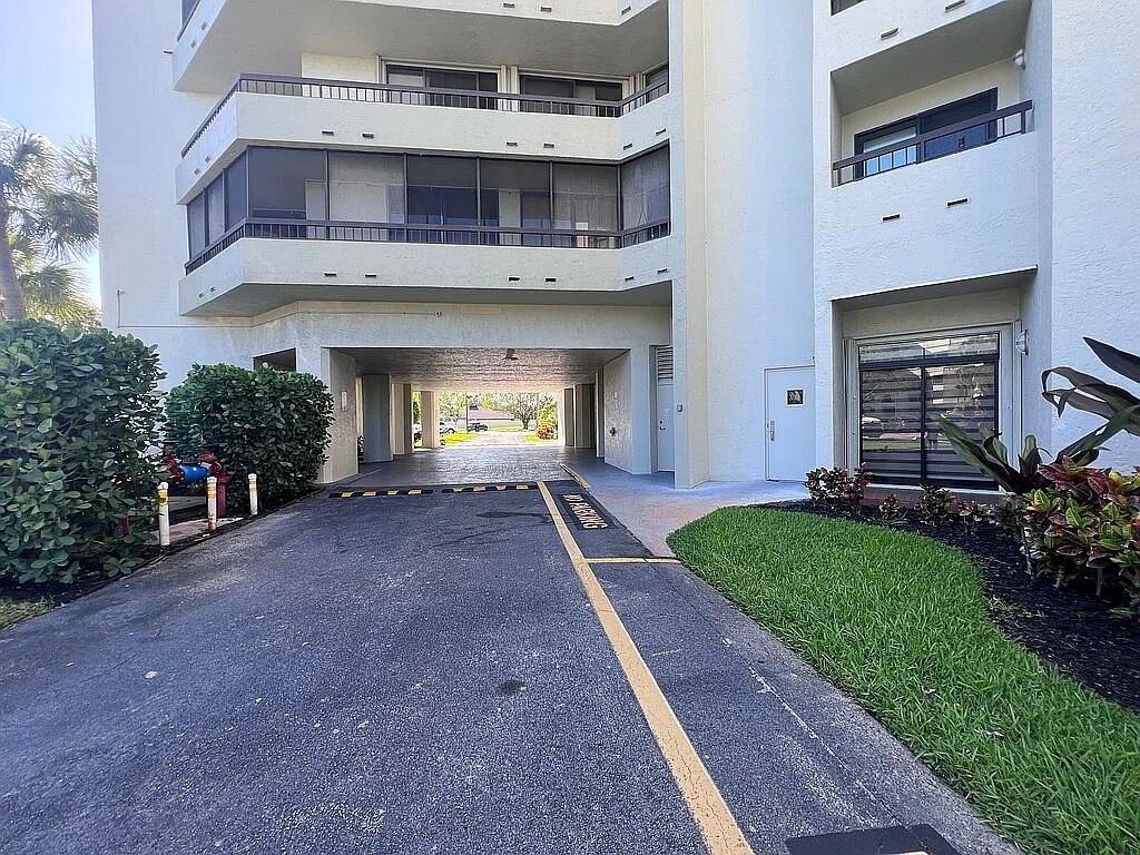 6463 La Costa Drive, Unit 105 Boca Raton, FL 33433 - Photo 33 of 40 a front view of a house with a yard and a garage