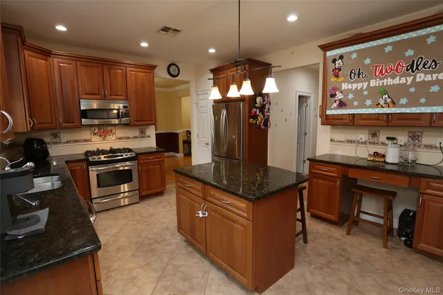 a kitchen with stainless steel appliances granite countertop a refrigerator and a stove