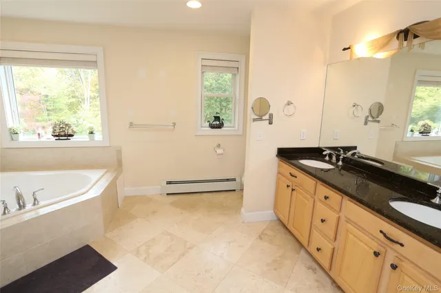 a spacious bathroom with a tub sink and mirror