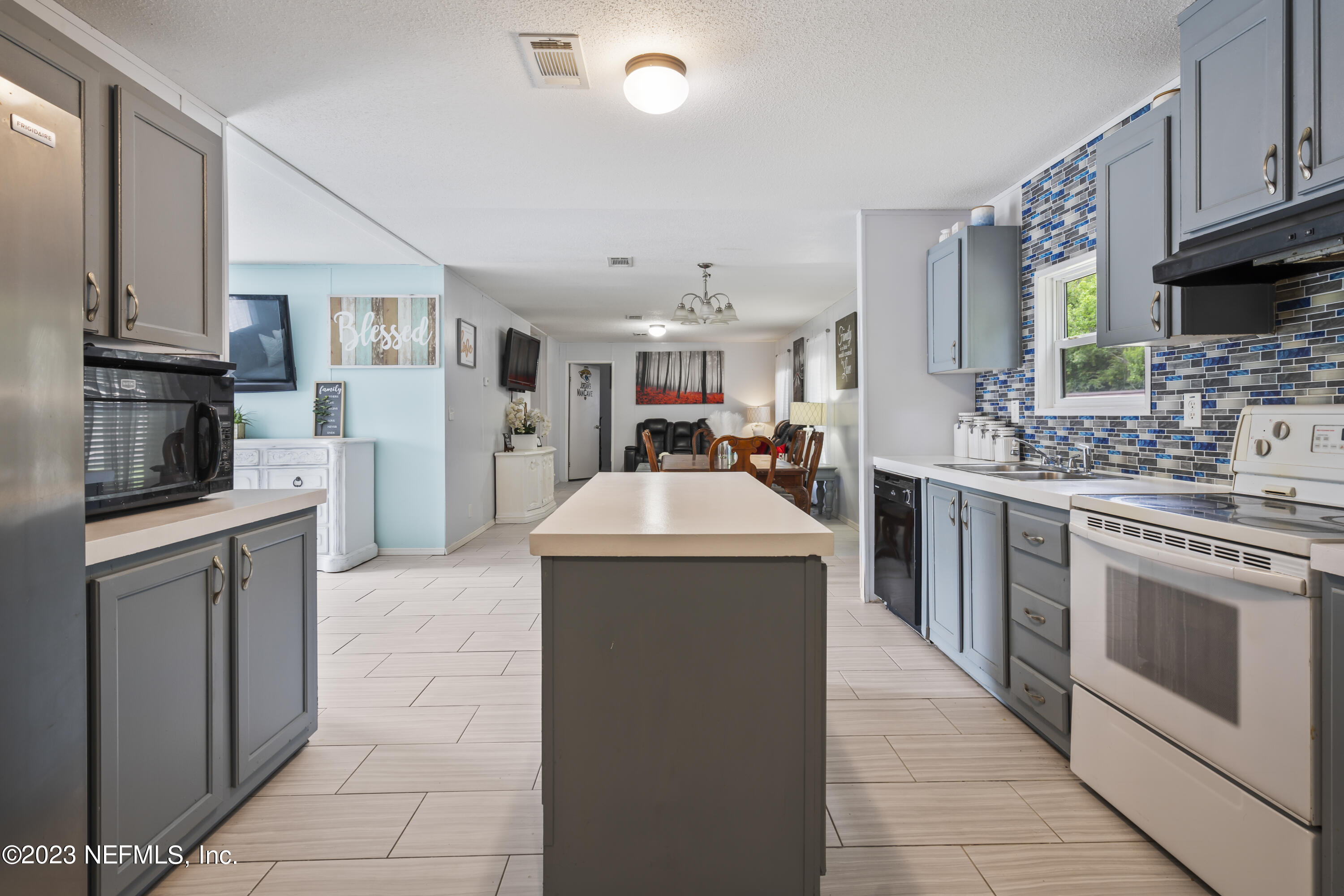 198 Yellow Water Road Baldwin, FL 32234 - Photo 14 of 37 a kitchen with stainless steel appliances a stove sink and cabinets