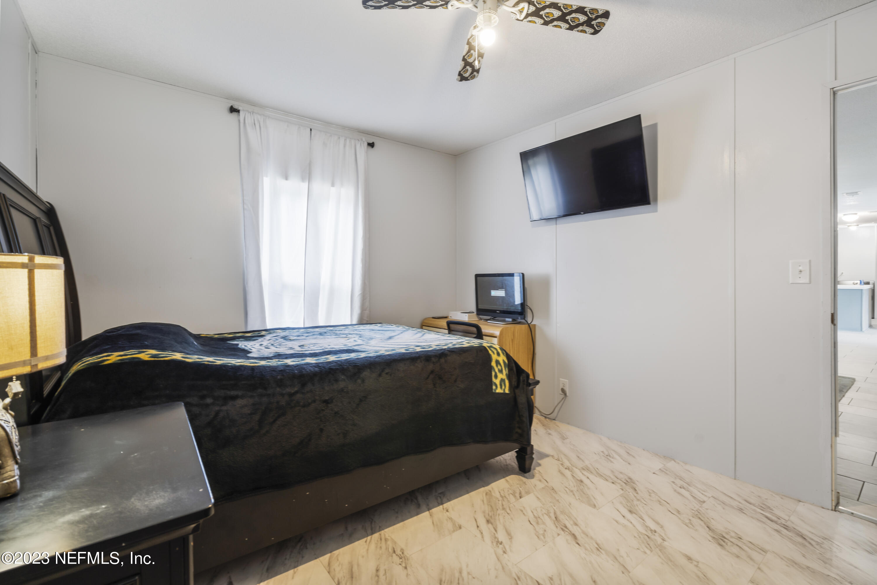 198 Yellow Water Road Baldwin, FL 32234 - Photo 16 of 37 a bedroom with a bed tv and a window