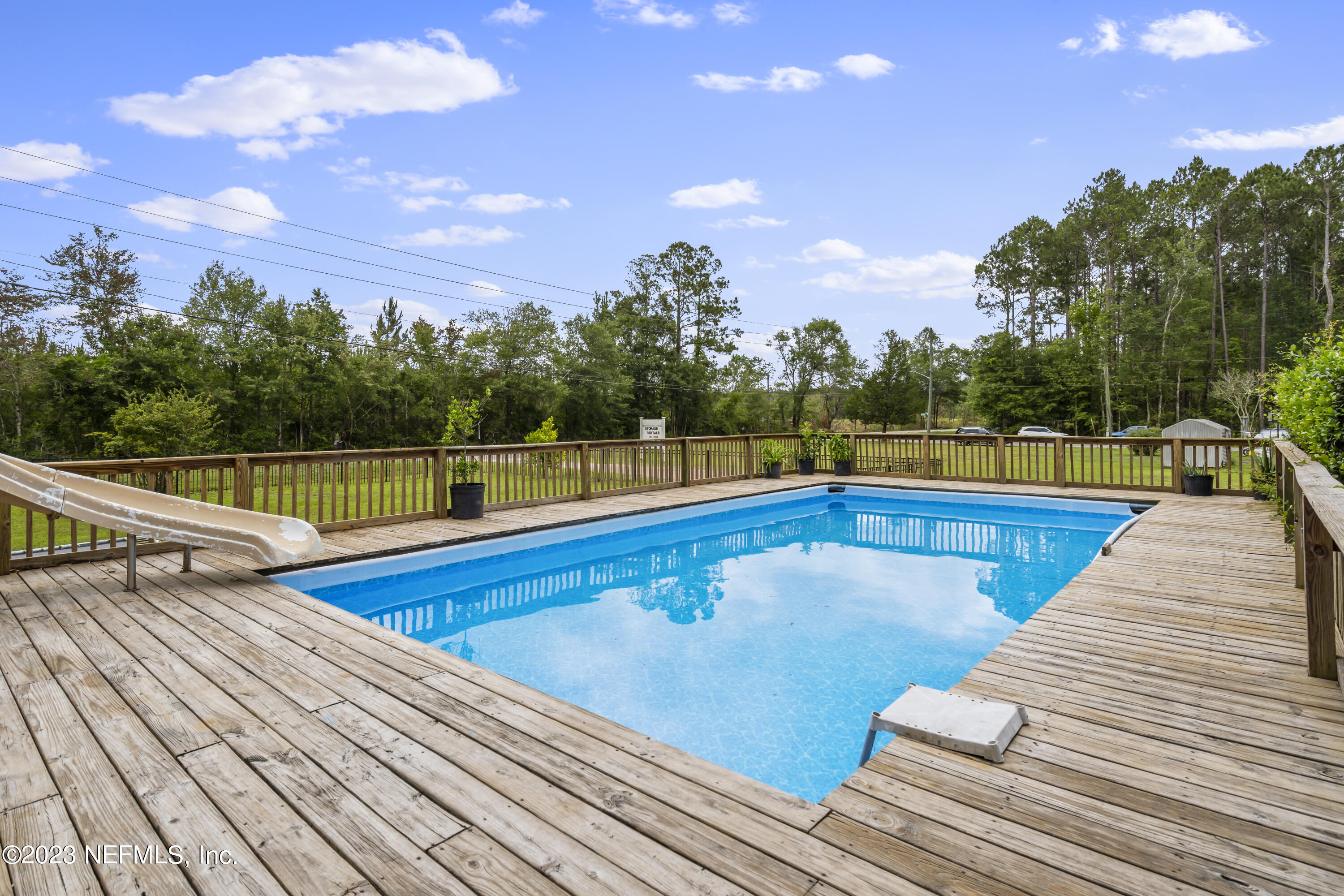 198 Yellow Water Road Baldwin, FL 32234 - Photo 33 of 37 a view of swimming pool with seating space and trees in the background