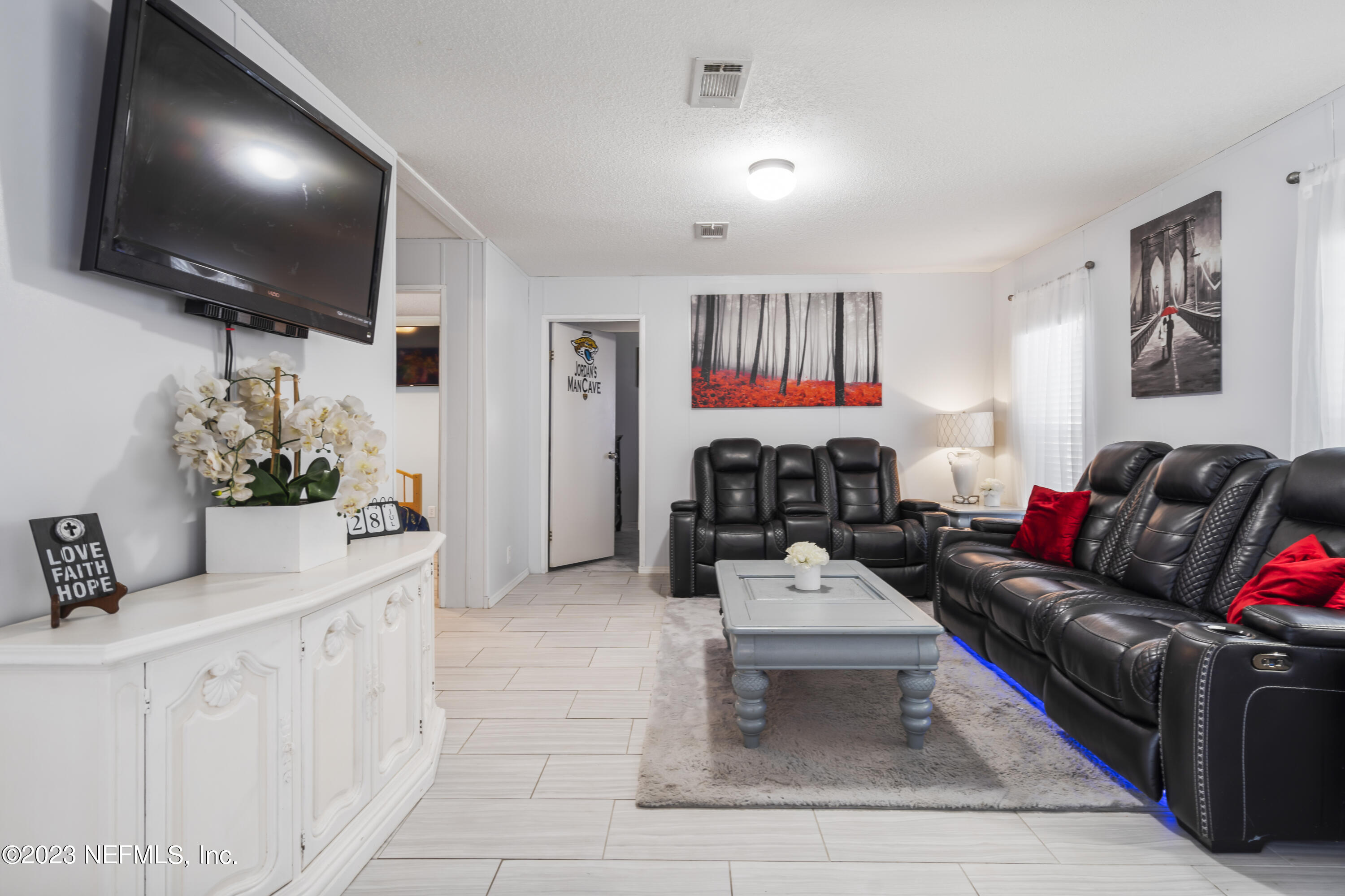 198 Yellow Water Road Baldwin, FL 32234 - Photo 7 of 37 a living room with furniture and a flat screen tv