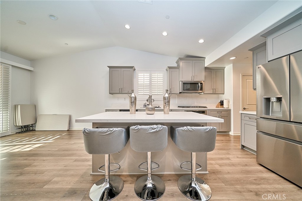7902 Ravello Court Highland, CA 92346 - Photo 11 of 52 a kitchen with stainless steel appliances granite countertop a dining table chairs refrigerator sink and cabinets