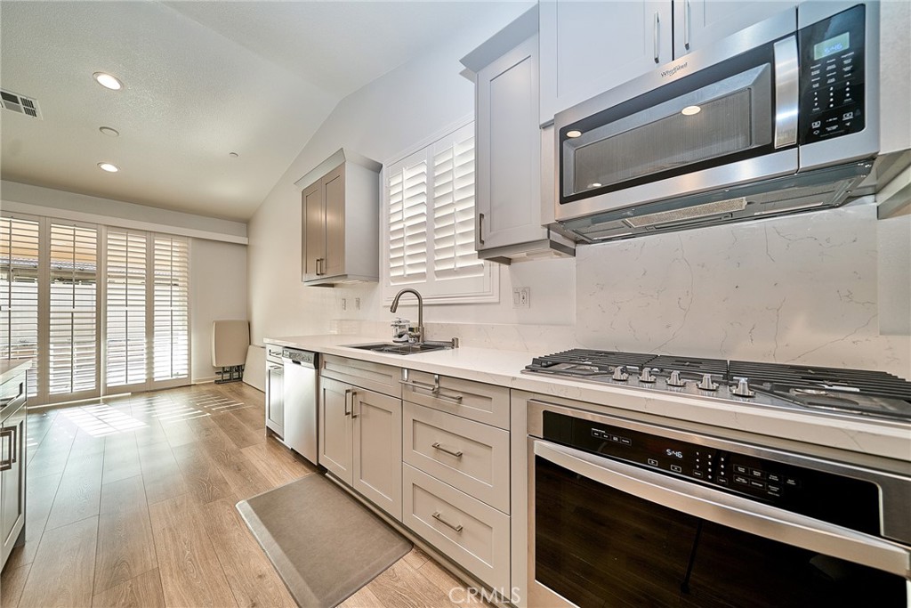 7902 Ravello Court Highland, CA 92346 - Photo 15 of 52 a kitchen with stainless steel appliances a stove microwave and cabinets