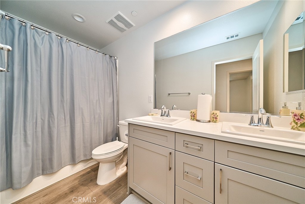 7902 Ravello Court Highland, CA 92346 - Photo 39 of 52 a bathroom with a double vanity sink toilet and a mirror
