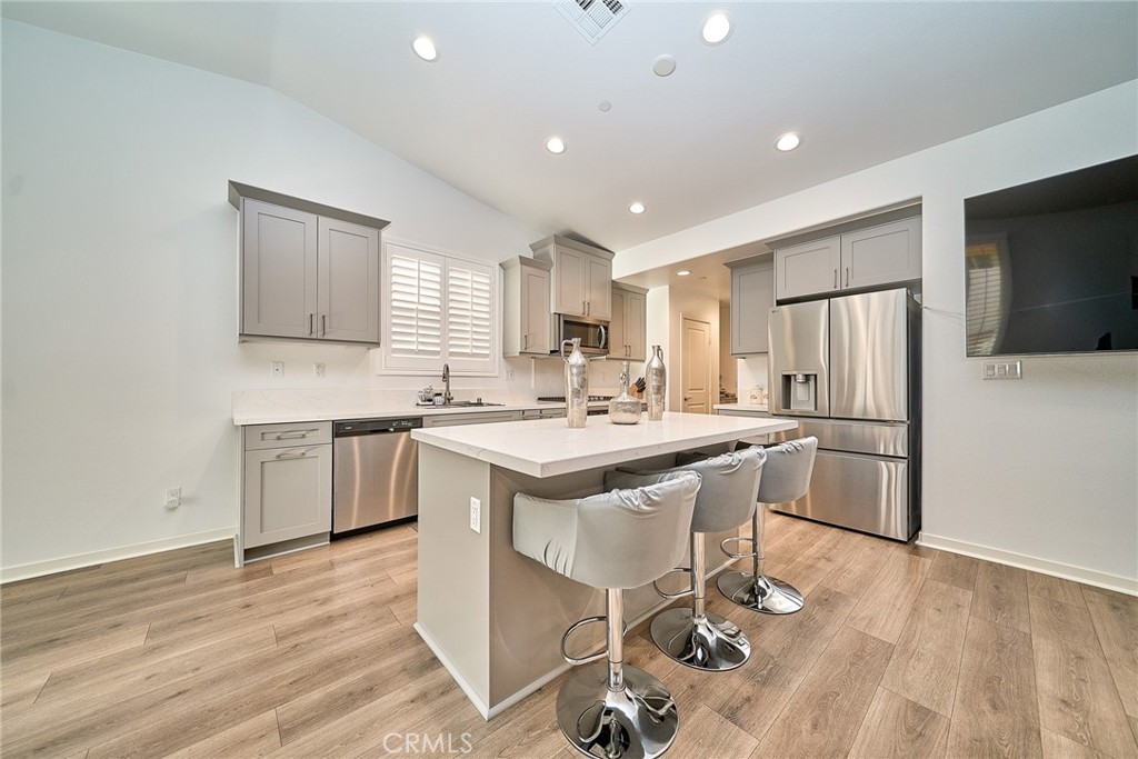 7902 Ravello Court Highland, CA 92346 - Photo 10 of 52 a kitchen with a sink a refrigerator a counter top space and cabinets