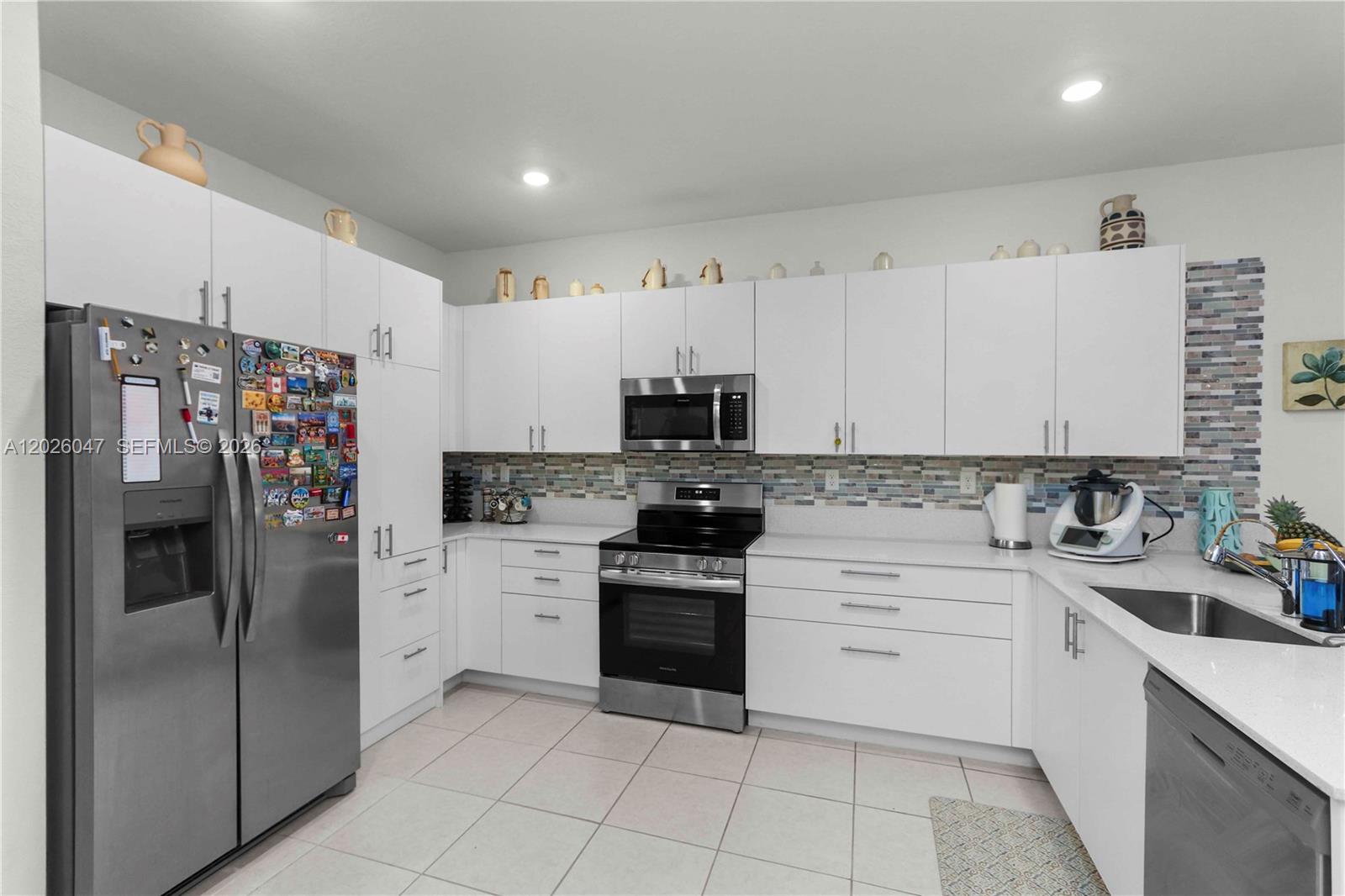 12862 Southwest 231st Street Miami, FL 33170 - Photo 13 of 30 a kitchen with stainless steel appliances cabinets a sink and a counter top space