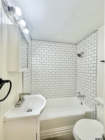 a white toilet sitting next to a bathroom sink