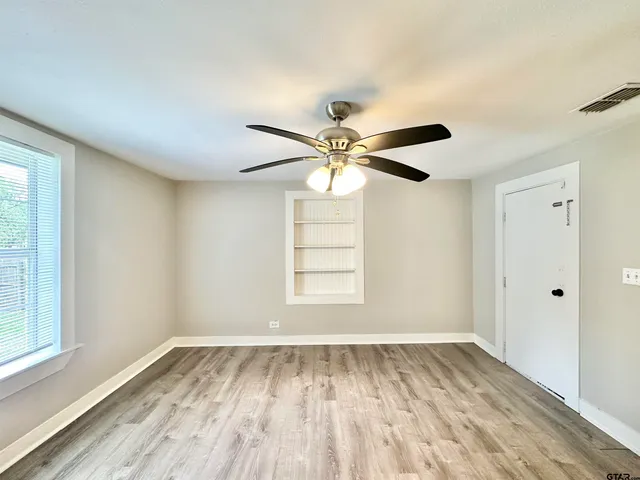 a view of a livingroom with wooden floor and a ceiling fan