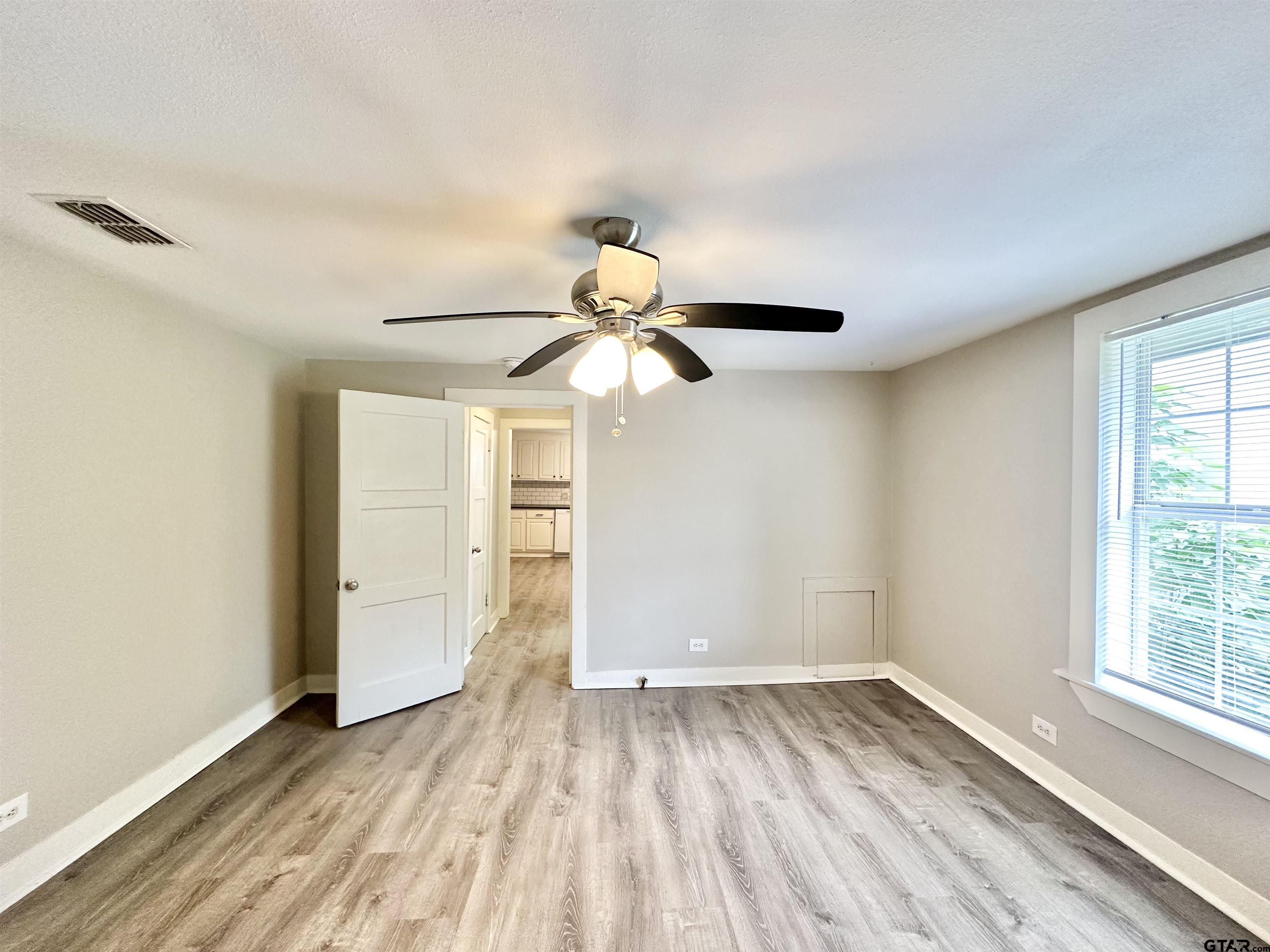 219 Half Street Lindale, TX 75771 - Photo 20 of 33 wooden floor in an empty room with a window