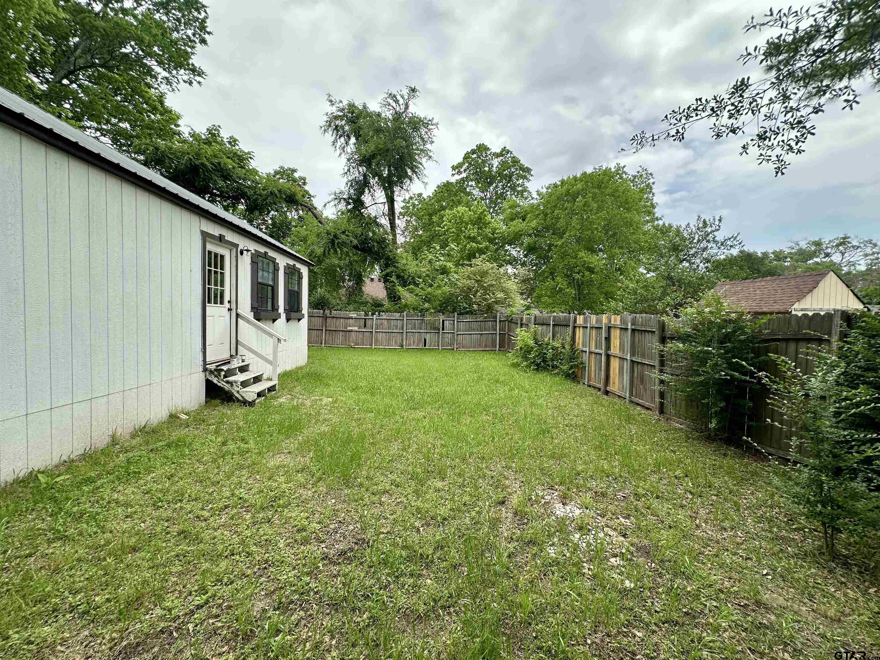 219 Half Street Lindale, TX 75771 - Photo 27 of 33 a backyard of a house with plants and tree