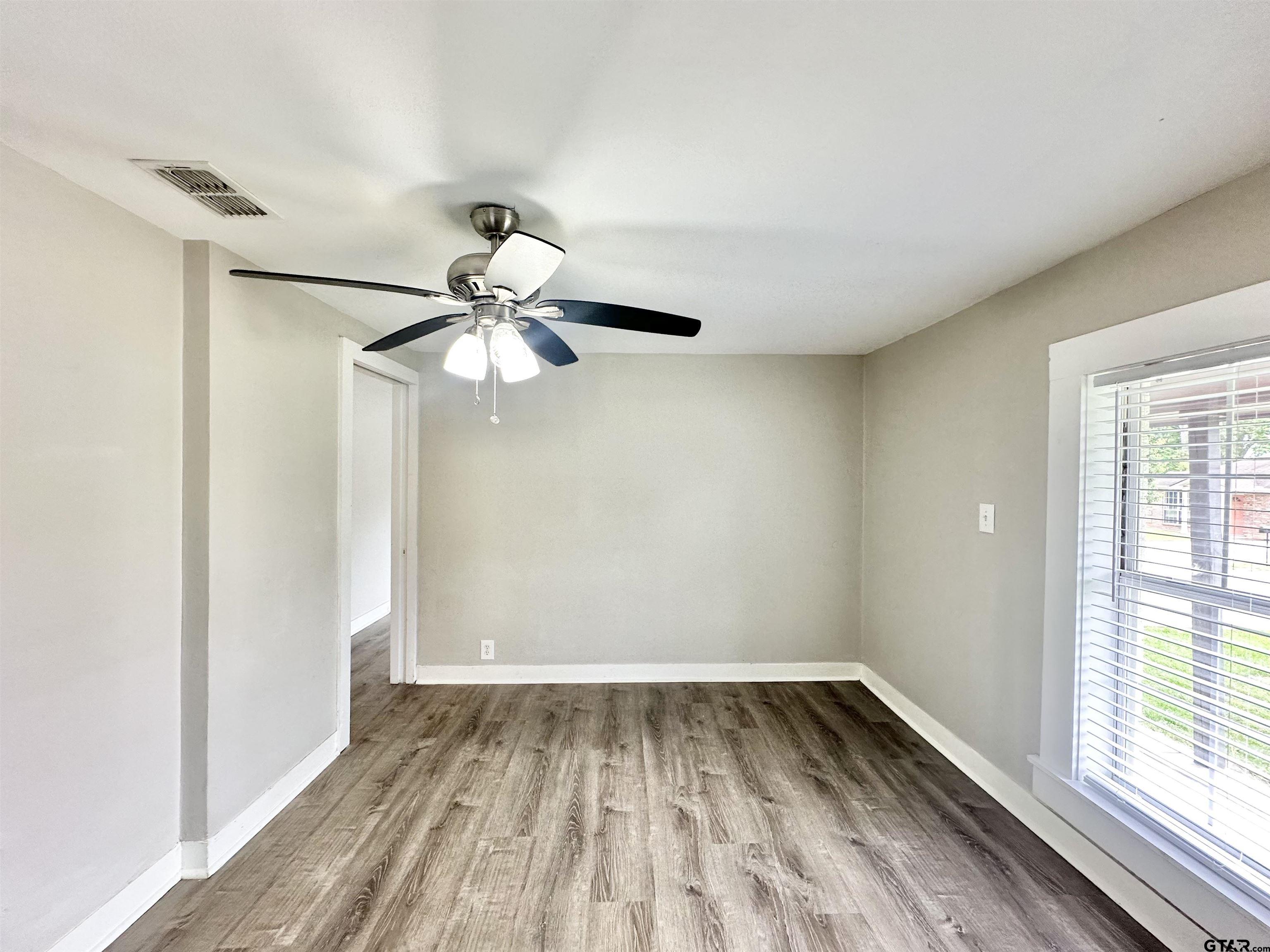 219 Half Street Lindale, TX 75771 - Photo 9 of 33 a view of a room with window ceiling fan and wooden floor