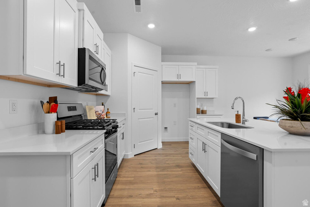 1624 South Staircase Way, Unit 4183 Washington, UT 84780 - Photo 22 of 47 Kitchen featuring light wood-finish flooring, white cabinetry with contemporary hardware, white countertops, stainless steel appliances, and recessed lighting