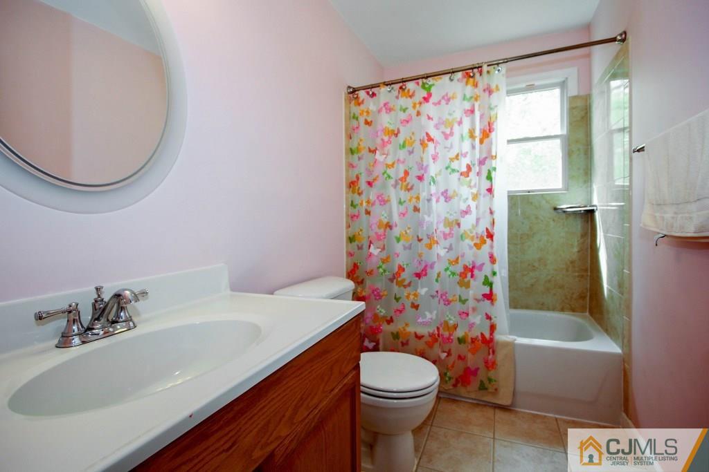 3 Markham Road Edison, NJ 08817 - Photo 20 of 23 a bathroom with a sink a toilet and shower curtain