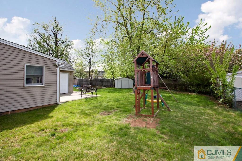 3 Markham Road Edison, NJ 08817 - Photo 22 of 23 a view of a backyard with table and chairs and potted plants and large trees