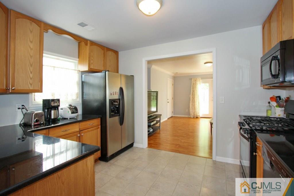 3 Markham Road Edison, NJ 08817 - Photo 8 of 23 a kitchen with stainless steel appliances granite countertop a refrigerator a stove and a sink with cabinets
