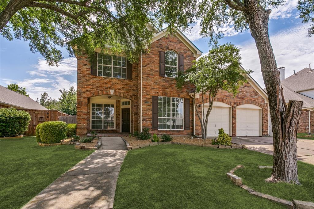 Traditional-style home with brick siding, a garage, and driveway