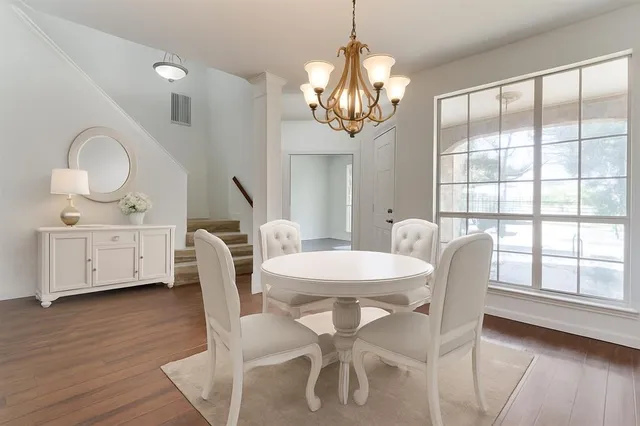 a view of a dining room with furniture a chandelier and wooden floor