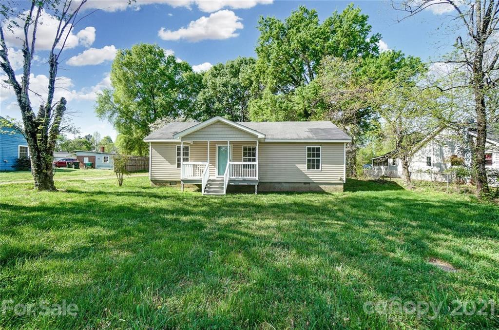 3003 Lowell Road Gastonia, NC 28054 - Photo 2 of 27 a view of a house with a big yard and large trees