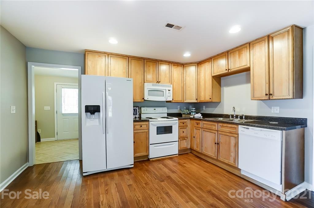 3003 Lowell Road Gastonia, NC 28054 - Photo 4 of 27 a kitchen with granite countertop wooden floors stainless steel appliances and window