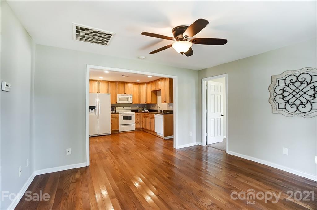 3003 Lowell Road Gastonia, NC 28054 - Photo 8 of 27 a view of a kitchen with wooden floor a ceiling fan and a window