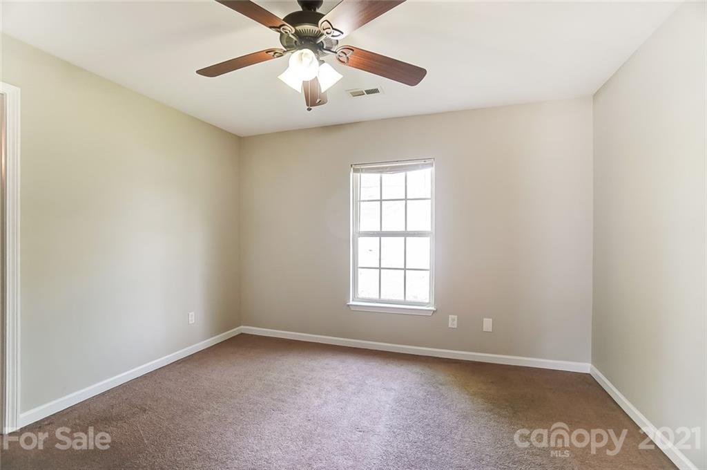 3003 Lowell Road Gastonia, NC 28054 - Photo 10 of 27 an empty room with windows and fan