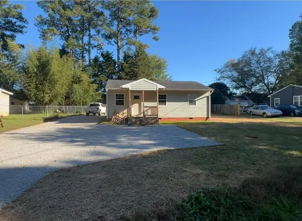 a front view of a house with a yard and trees