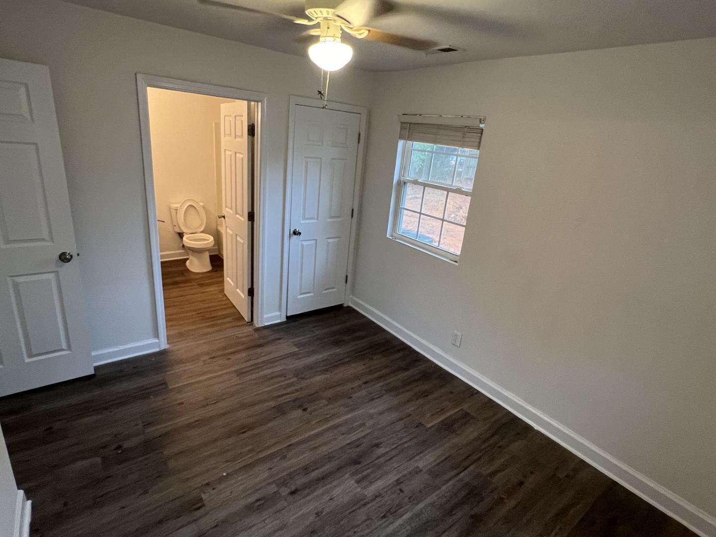 222 Weston Road Garner, NC 27529 - Photo 12 of 27 a view of an empty room with wooden floor and a window