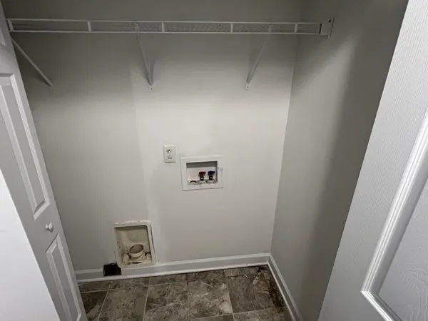 a view of storage and utility room with hardwood floor