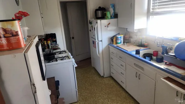 a kitchen with sink a refrigerator and cabinets