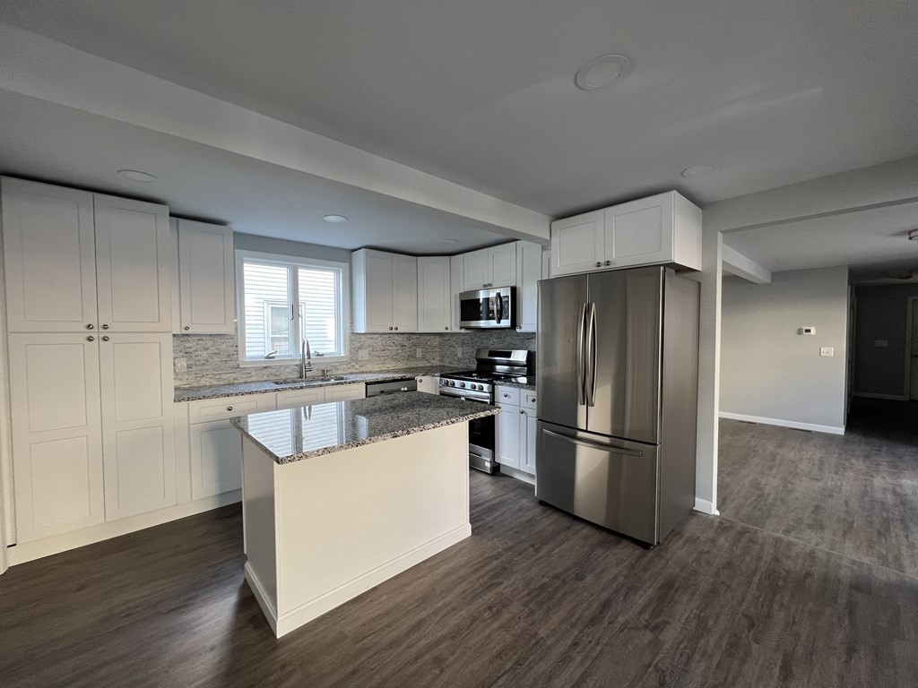 45 Loring Street Springfield, MA 01105 - Photo 5 of 16 a kitchen with kitchen island a refrigerator and wooden floor