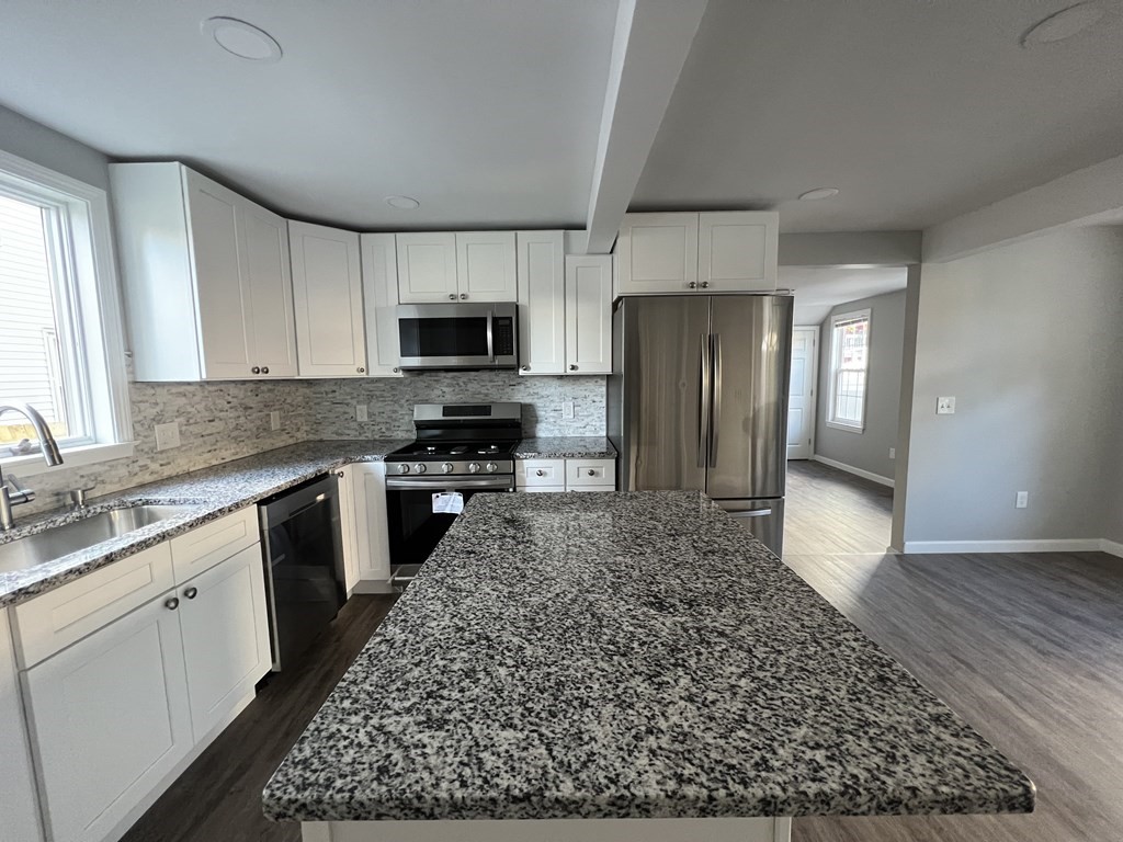 45 Loring Street Springfield, MA 01105 - Photo 6 of 16 a kitchen with granite countertop a refrigerator and a stove top oven