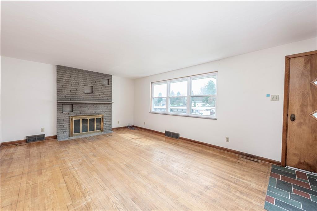 6576 Library Road South Park, PA 15129 - Photo 13 of 31 wooden floor fireplace and windows in an empty room