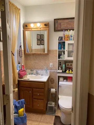 a bathroom with a toilet sink vanity and mirror