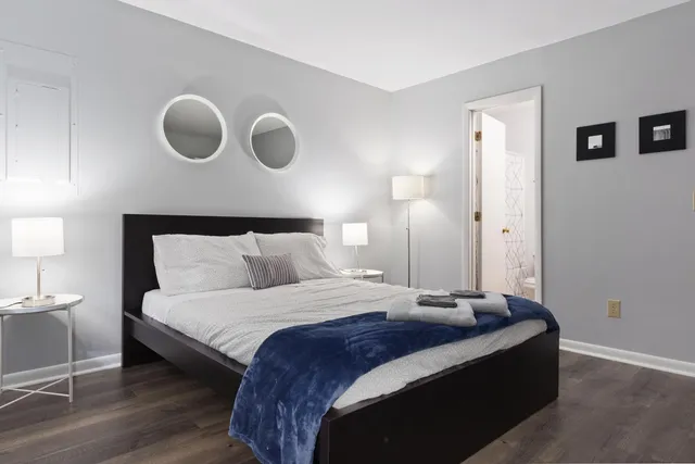 a bedroom with bed and a large mirror