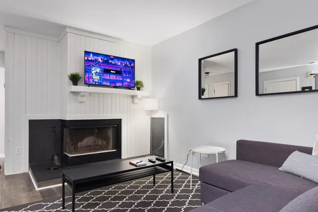 a living room with furniture a fireplace and paintings on the wall