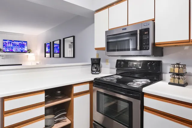 a kitchen with stainless steel appliances a stove microwave and sink