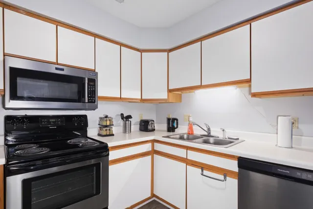 a kitchen with stainless steel appliances a stove a sink and a microwave