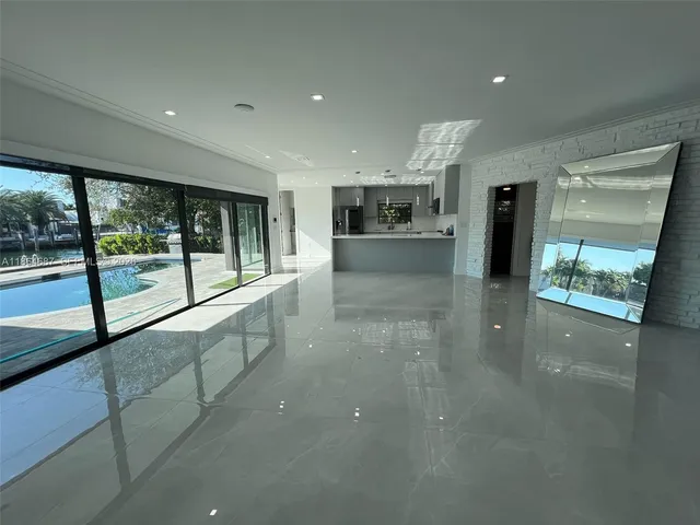 a view of a kitchen with kitchen island a sink wooden floor and a large window