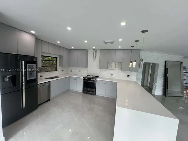 a large kitchen with stainless steel appliances kitchen island a large counter top and a sink